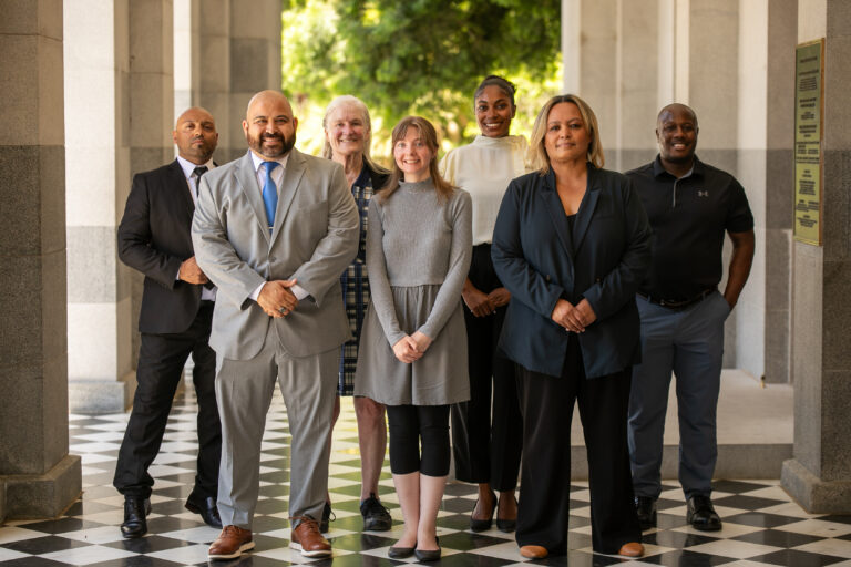 Diverse group of professionals standing together in a courthouse, representing legal education for professionals